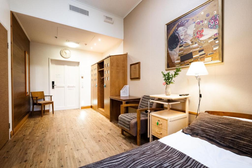 ein Hotelzimmer mit einem Bett, einem Schreibtisch und einem Stuhl in der Unterkunft Hotel Kruunupuisto in Punkaharju
