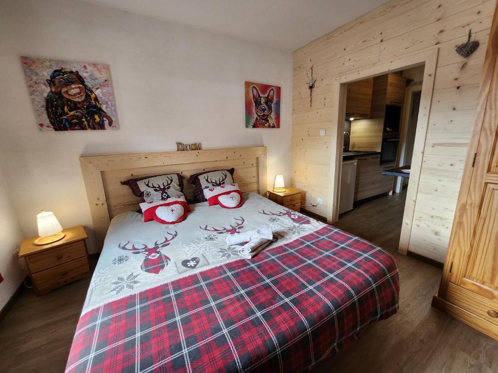 a bedroom with a bed with a red plaid blanket at Gite Myosotis 2 personnes avec SPA Jacuzzi , jardin, barbecue, dans la Résidence in Ventron
