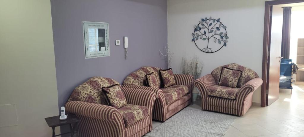 a living room with two chairs and a table at Cozy 2BHK Near to DMCC Metro Station -505 in Dubai