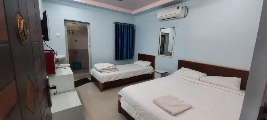 a hotel room with two beds and a mirror at KN residency, near Trichy Airport in Tiruchchirāppalli