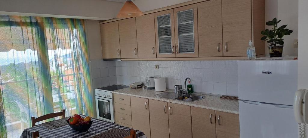 a kitchen with a table and a white refrigerator at Gavrihl home in Kavala