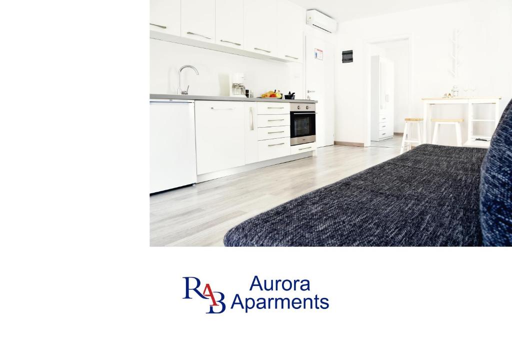 eine Küche mit weißen Schränken und einem schwarzen Teppich in der Unterkunft Rab apartments AURORA in Rab