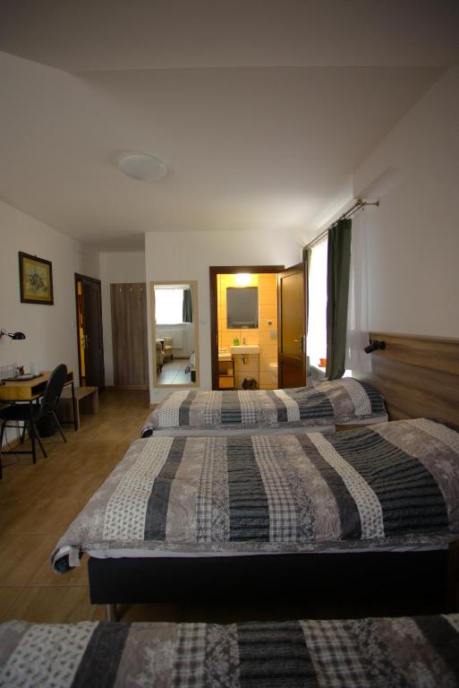 a hotel room with two beds and a desk at Stara Szkoła in Sokółka
