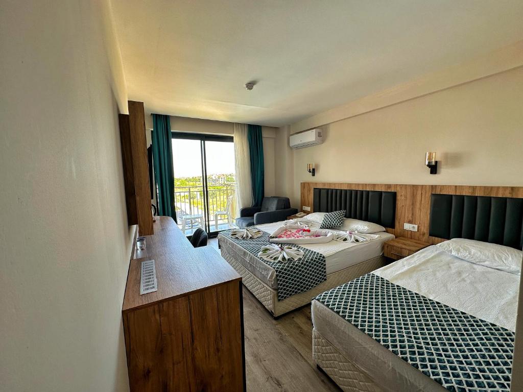 Zimmer mit 2 Betten und einem Wohnzimmer in der Unterkunft KAYA GARDEN OTEL in Side