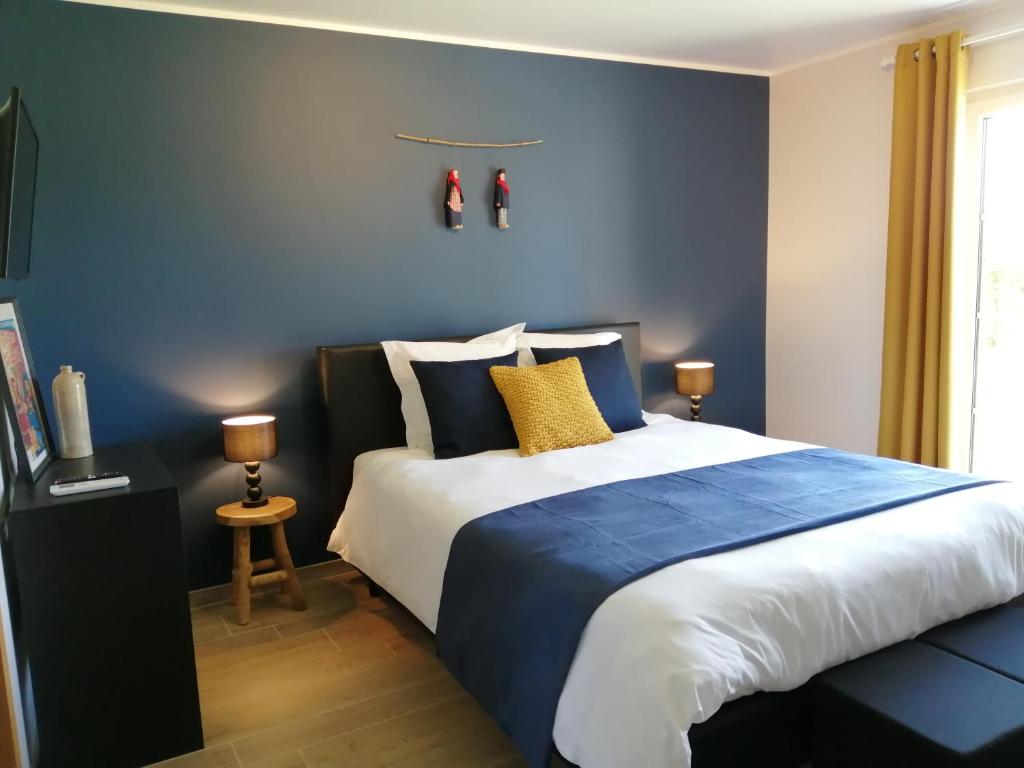 een slaapkamer met een groot bed met blauwe muren bij En Vert & En Pause in Thimister
