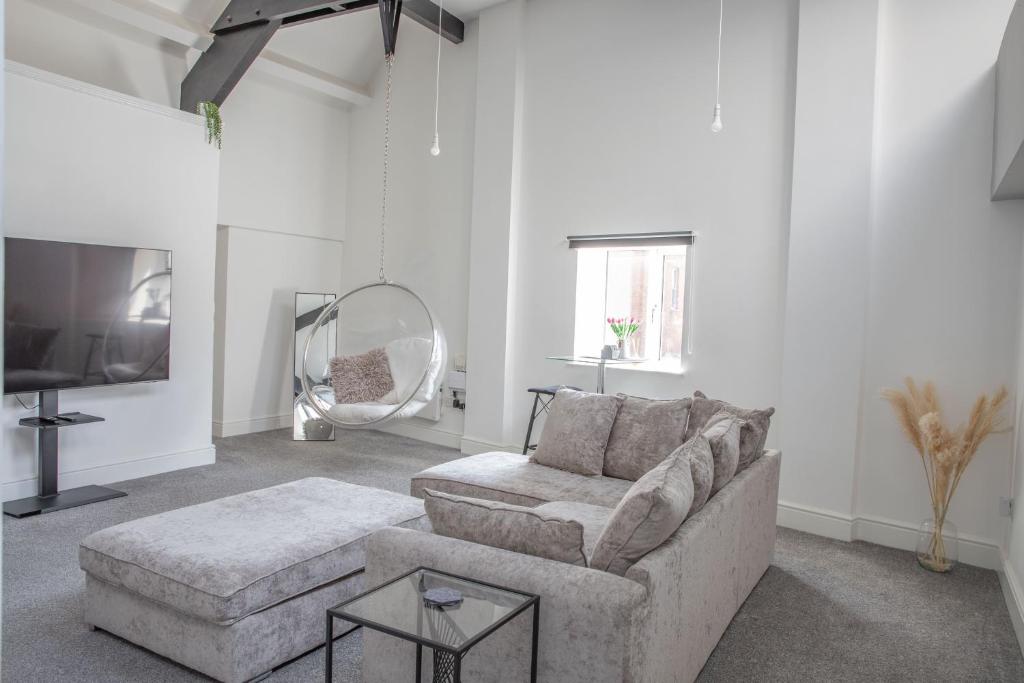 a white living room with a couch and a mirror at #5 Grimston St Apartment near Hull New Theatre and Connexin Live in Hull