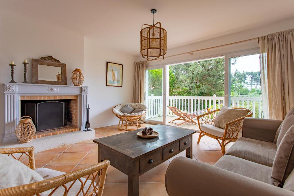 a living room with a couch and a fireplace at Villa des Sables in Lège-Cap-Ferret