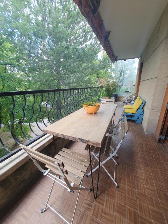a large wooden table and chairs on a balcony at Magnifique Appartement en ville in Aix-en-Provence
