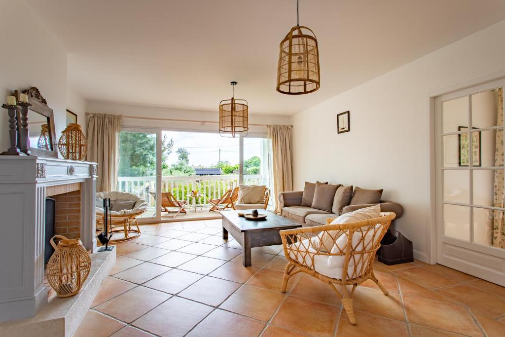 a living room with a couch and a fireplace at Villa des Sables in Lège-Cap-Ferret