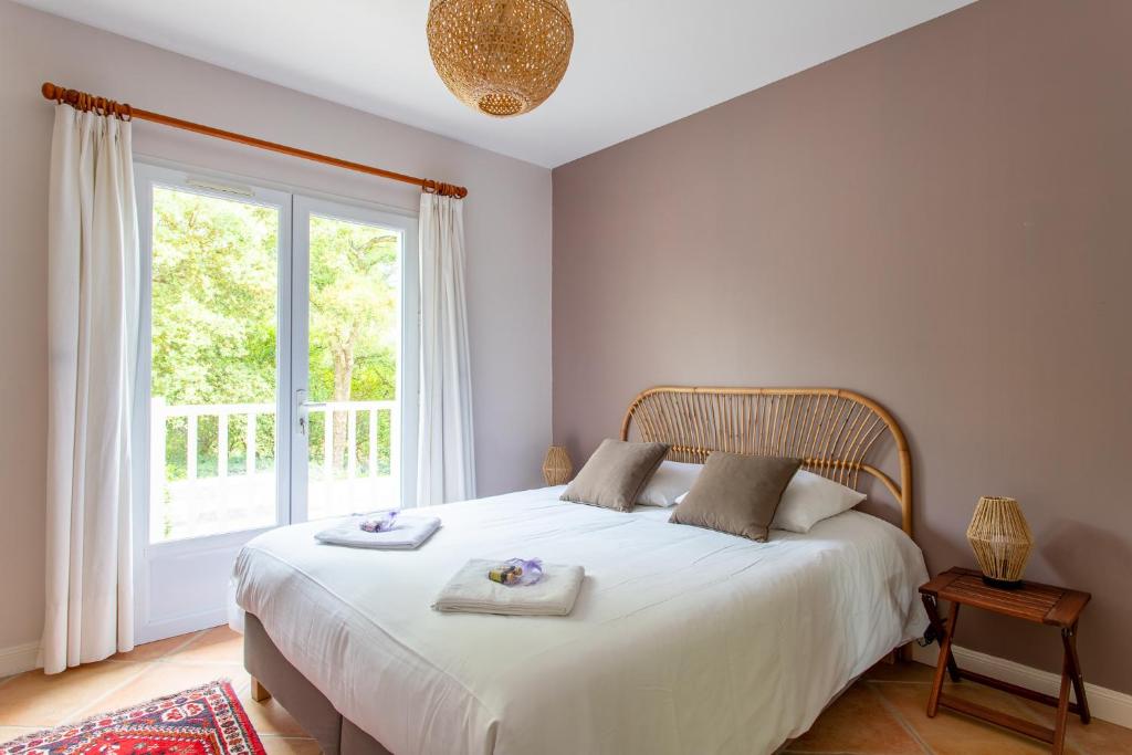 a bedroom with a large white bed with towels on it at Villa des Sables in Lège-Cap-Ferret