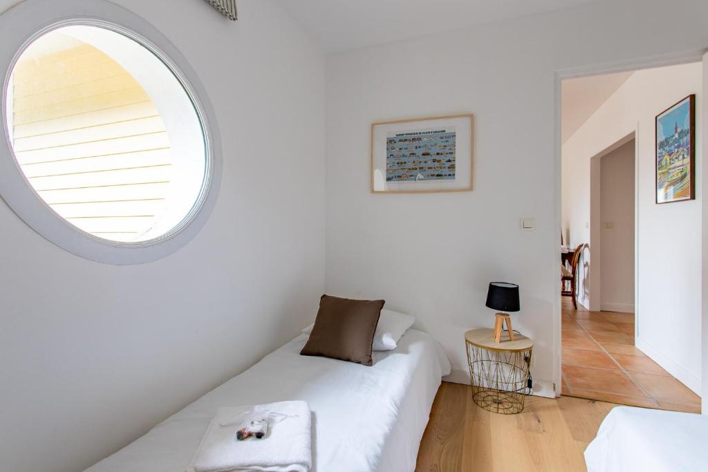 a room with a white couch and a round window at Villa des Sables in Lège-Cap-Ferret