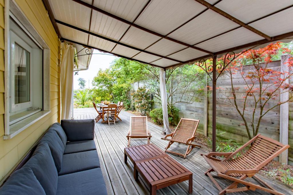 a patio with a couch and chairs and a table at Villa des Sables in Lège-Cap-Ferret