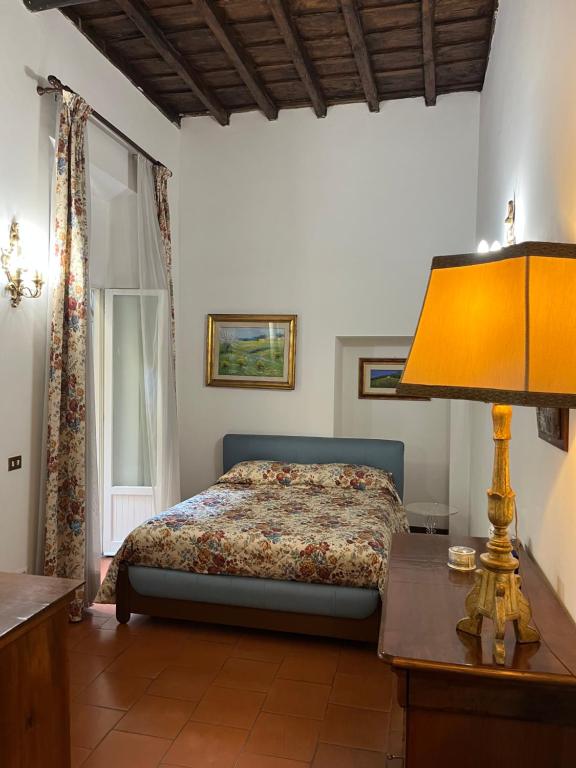 ローマにあるAnnemary Maisonのベッドルーム1室(ベッド1台、ランプ付きテーブル付)