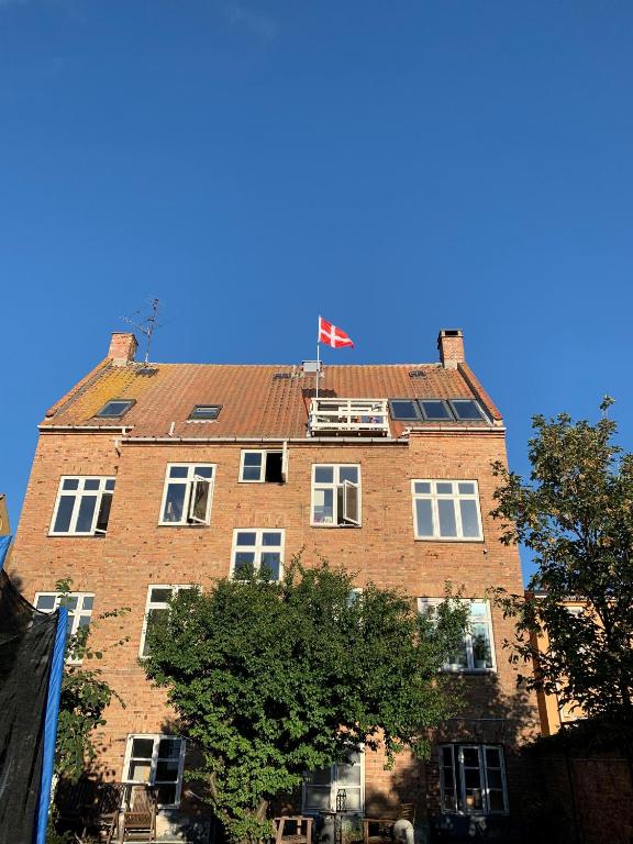 a tall brick building with a flag on top of it at Udsigt Østersøen in Rønne