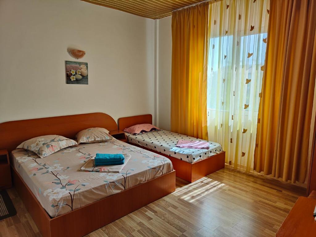 1 dormitorio con 2 camas y ventana en Vila Olimpica, en Costinesti