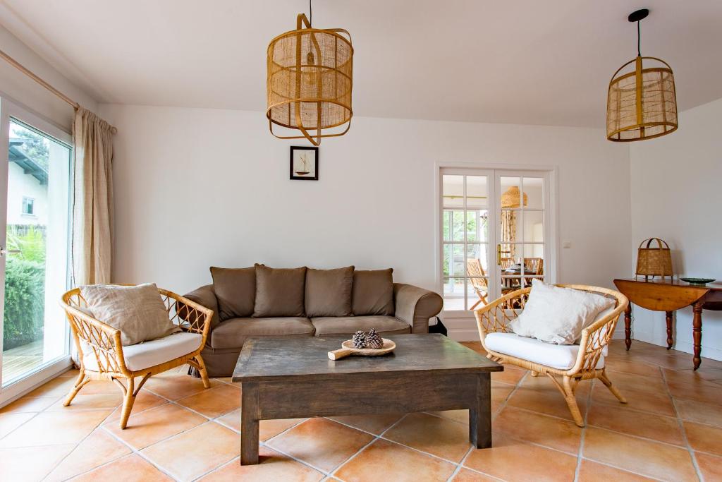 a living room with a couch and chairs at Villa des Sables in Lège-Cap-Ferret