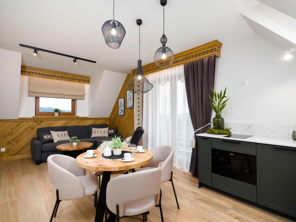a living room with a table and chairs and a couch at Apartamenty Górski Prestige in Białka Tatrzanska