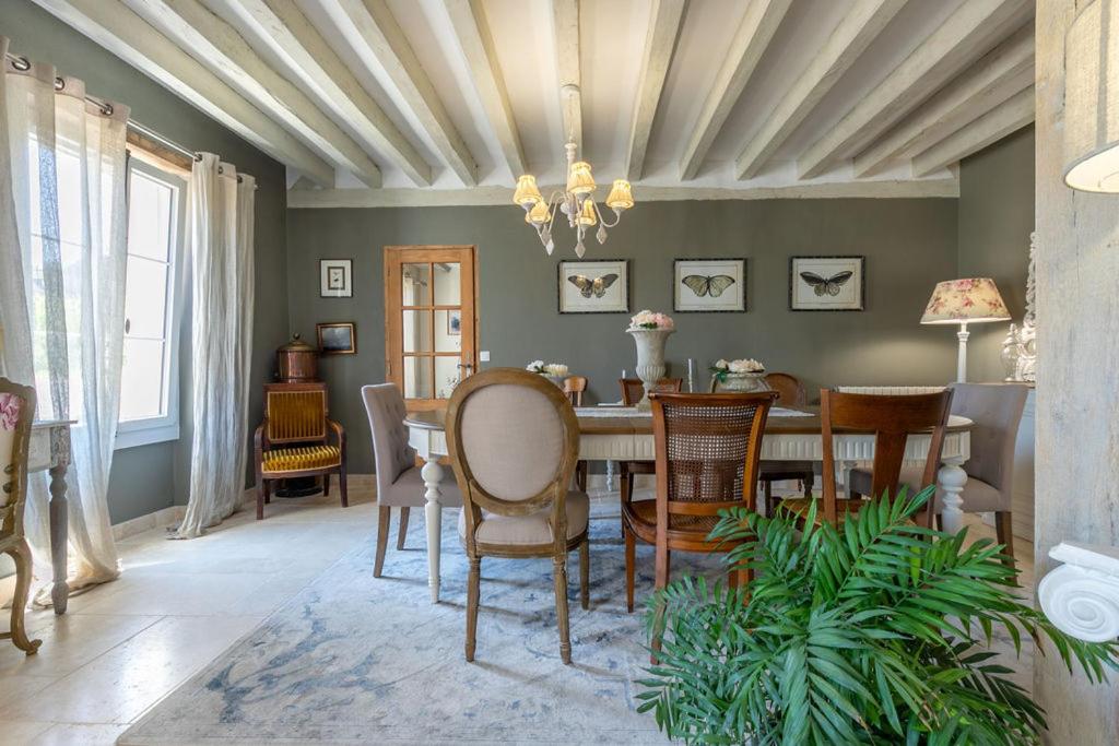 jadalnia ze stołem i krzesłami w obiekcie Le Clos des Roses Chambres et Tables d hôtes w mieście Meusnes