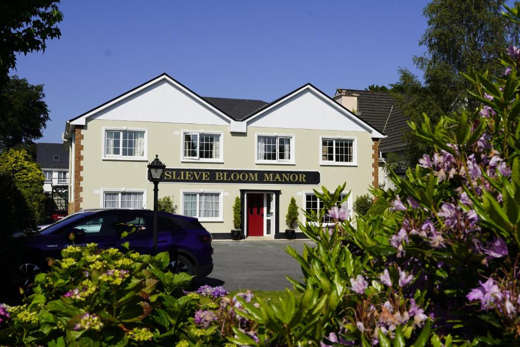 una casa con un coche aparcado delante de ella en Slieve Bloom Manor Hostel, en Killarney