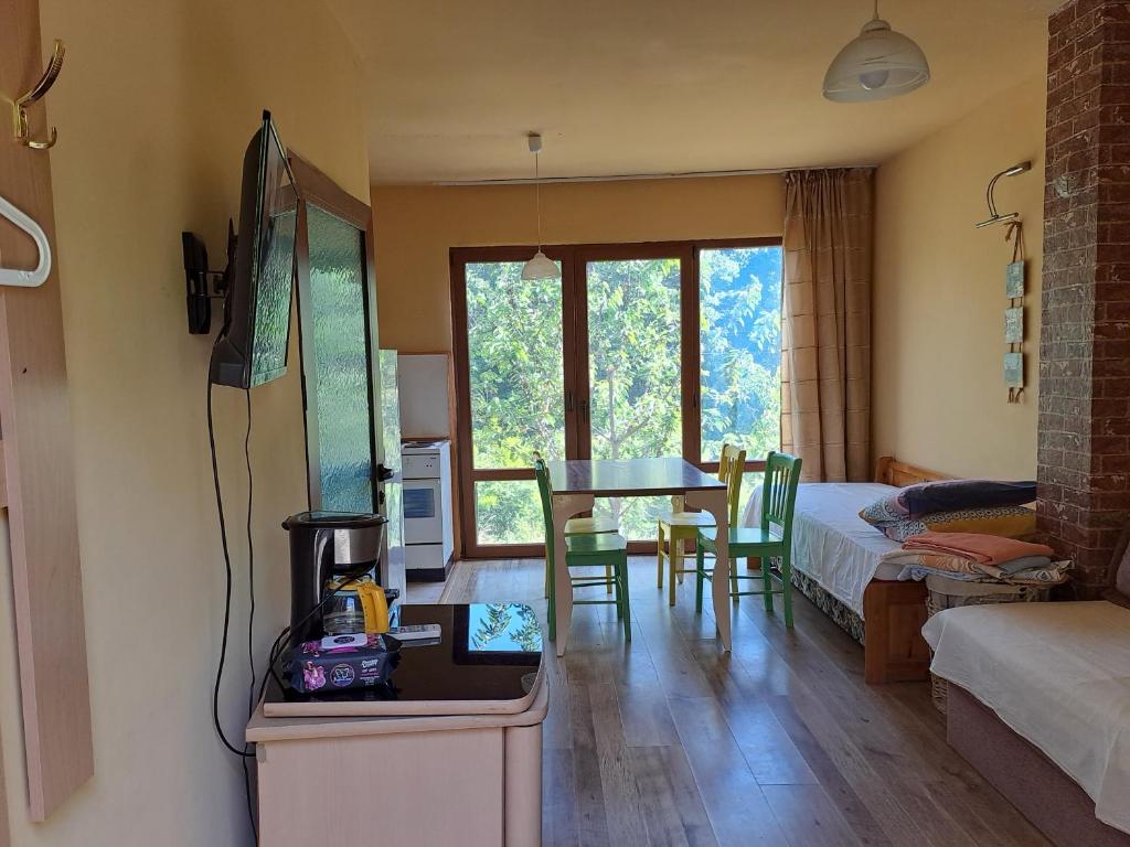 1 dormitorio con 1 cama y 1 mesa con sillas en Yellow villa, en Sinemorets