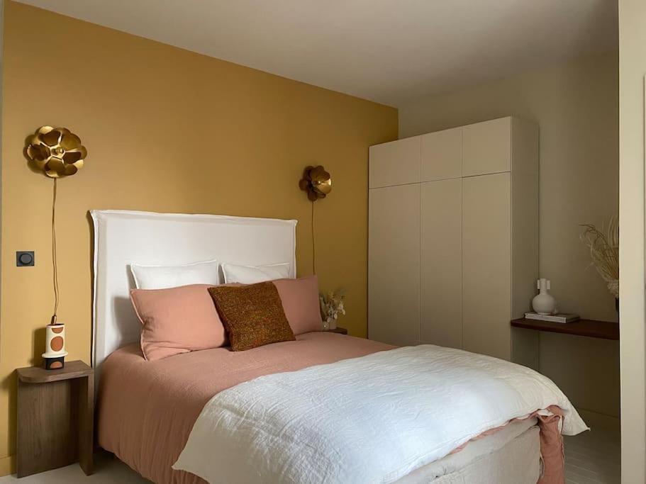 une chambre avec un lit avec des oreillers roses et blancs dans l'établissement WELCOMING, LOVELY, CALM & CENTRALLY LOCATED FLAT, à Dijon