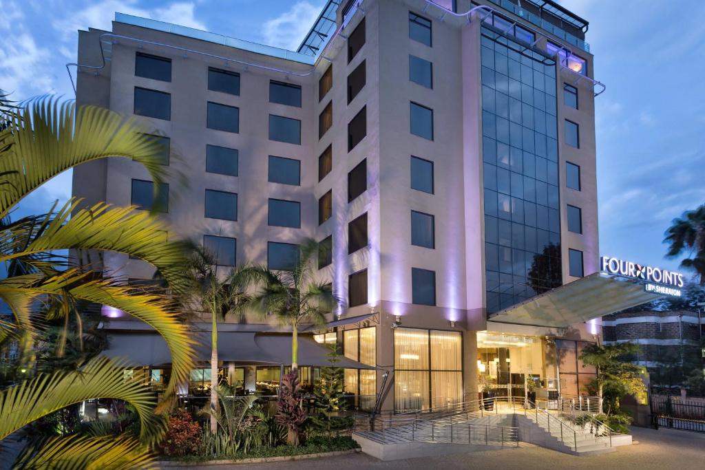 a hotel building with palm trees in front of it at Four Points By Sheraton Nairobi Hurlingham in Nairobi