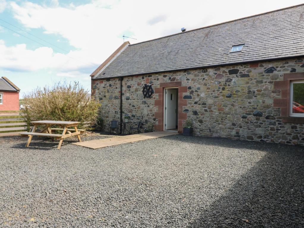 a stone building with a picnic table next to it at Dubh Sgeir Annex in Berwick-Upon-Tweed