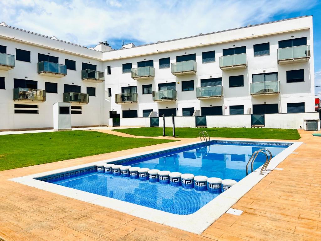 een zwembad voor een gebouw bij Apartamento con Piscina y Jardín Espectacular Cala Sirenas - Nuevo in Miami Platja