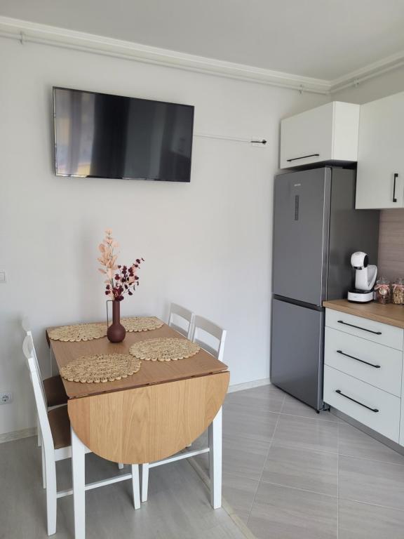 a kitchen with a table and a refrigerator at Amparo in Satu Mare