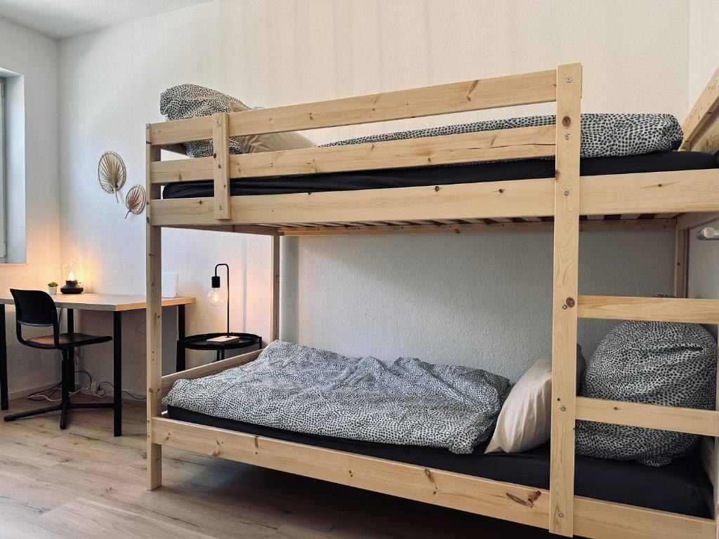 a bedroom with two bunk beds with a desk at FeWo Am Ring - mit Terrasse in Nordhorn