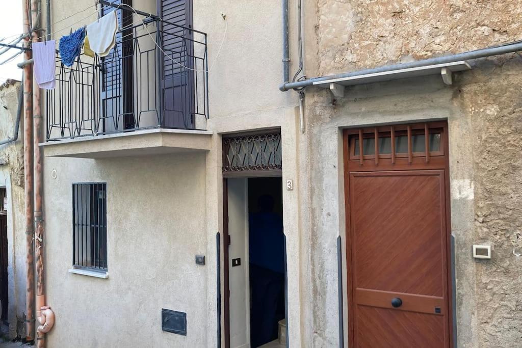 un edificio con porta marrone e balcone di Tenuta Balabaia, Townhouse. a Caccamo