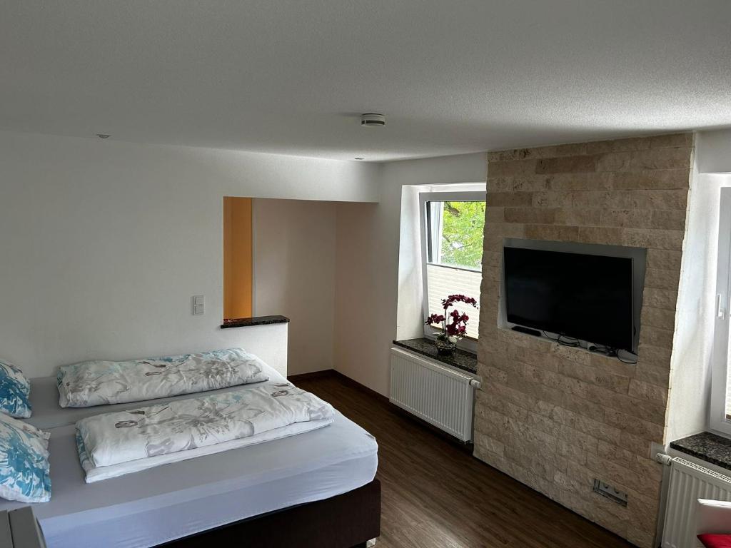 a bedroom with a bed and a flat screen tv at Alte Schmiede - XXL Foodhouse in Kempten