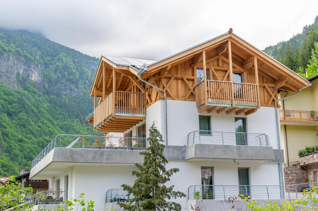 ein Haus mit Holzbalkonen auf einem Berg in der Unterkunft Dolomites Chalet Wolf in Molveno