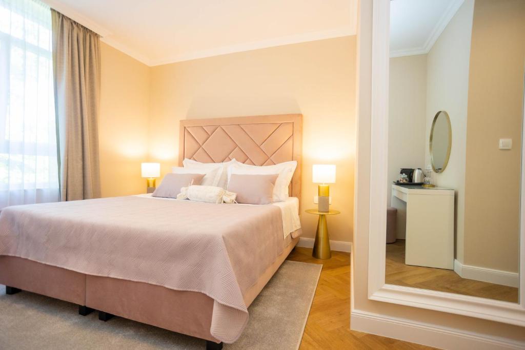 1 dormitorio con 1 cama grande y espejo en City and Style Luxury Rooms Split 2 en Split