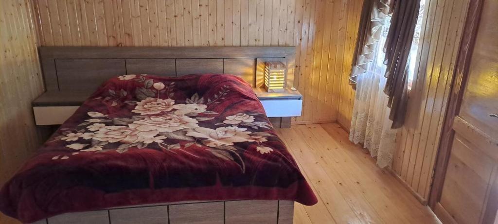 Posto letto in camera con pavimento in legno. di Guest house Lailashi a Surmushi