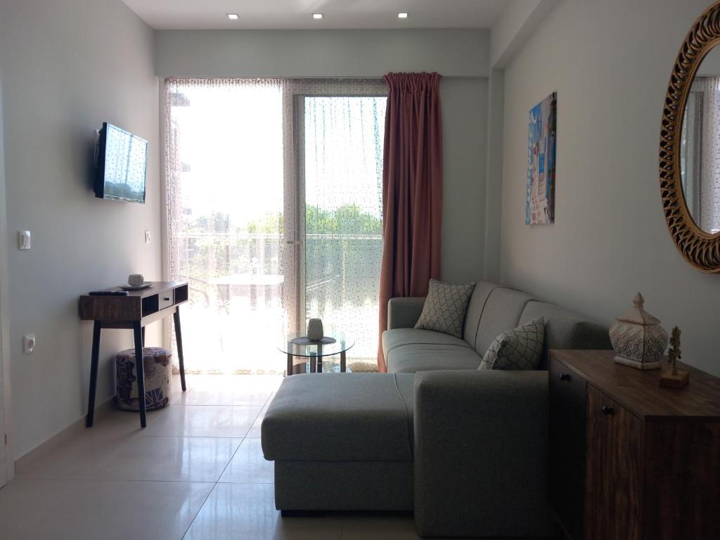 a living room with a couch and a large window at Bella Luxury Suite in Paralia Katerinis
