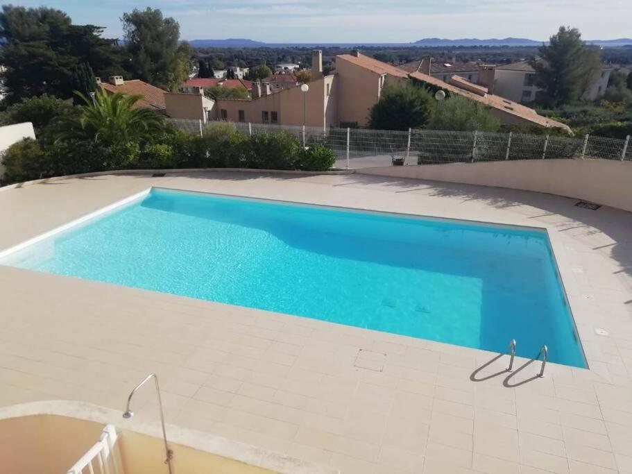 - une piscine dans une villa avec vue dans l'établissement 3 pièces 62m2 balcon vue mer accès piscine tennis, à Hyères