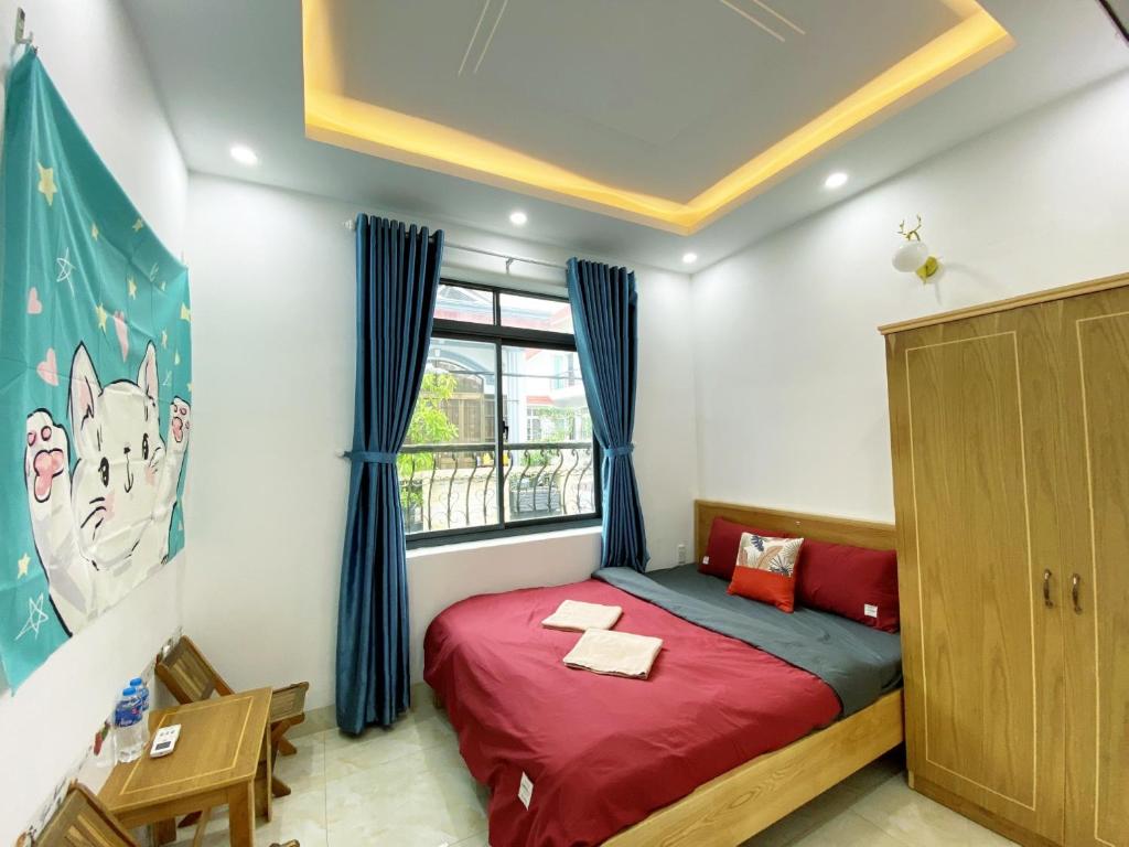 a bedroom with a red bed and a window at Prana Vũng Tàu in Vung Tau