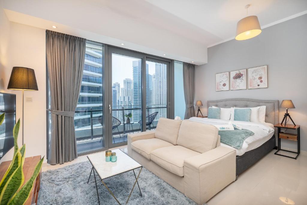 um quarto com um sofá e uma grande janela em Prime Stylish Studio with Marina Views no Dubai