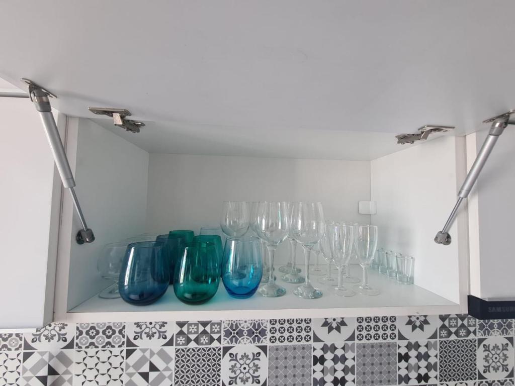 a shelf filled with wine glasses on a wall at Spacious&modern 4 rooms apartment in Târgu-Mureş