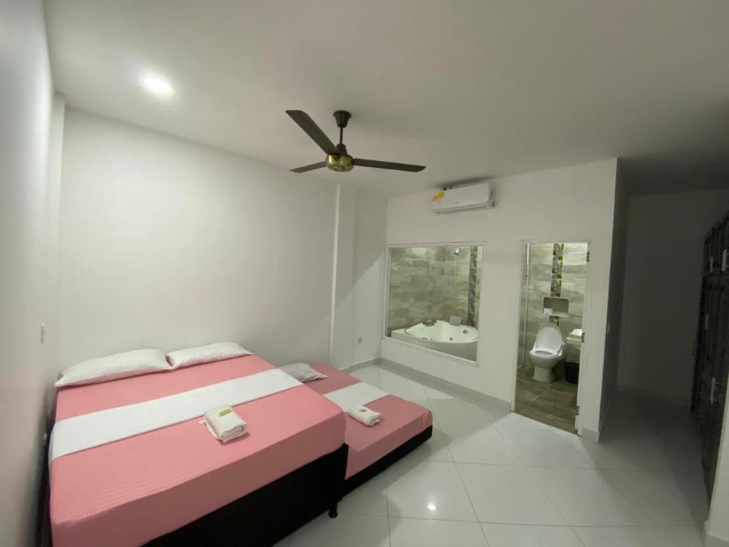 a bedroom with a pink bed and a bathroom at APARTAMENTO DORADAL in Doradal