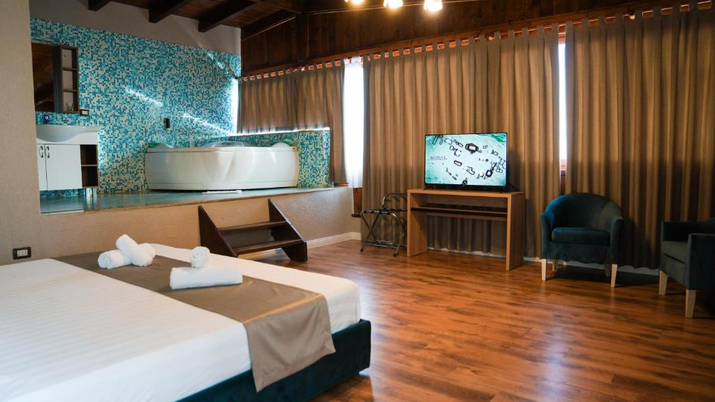 a hotel room with a bed and a tub and a television at Hotel Majestic in Durrës