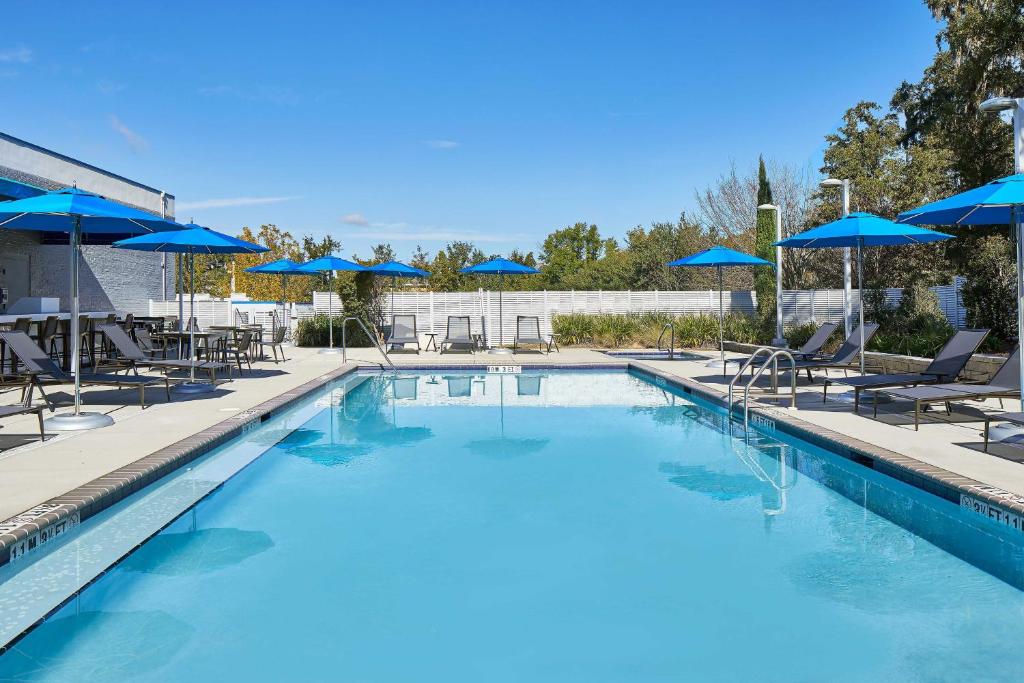 una grande piscina con sedie e ombrelloni di Four Points by Sheraton Tallahassee Downtown a Tallahassee