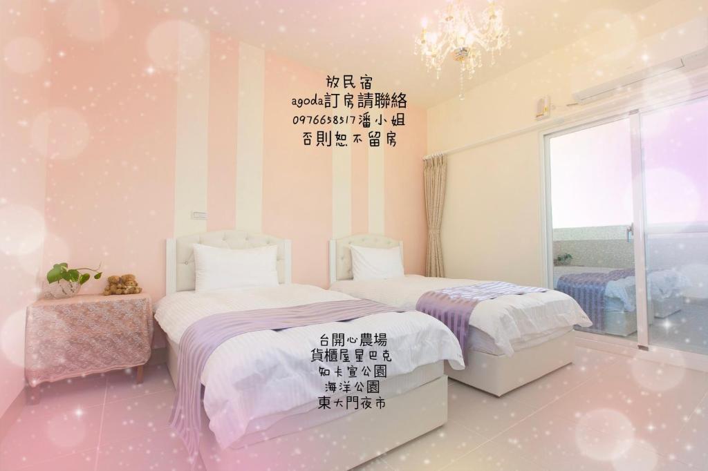 2 camas en una habitación con palabras en la pared en Fun Homestay en Jian