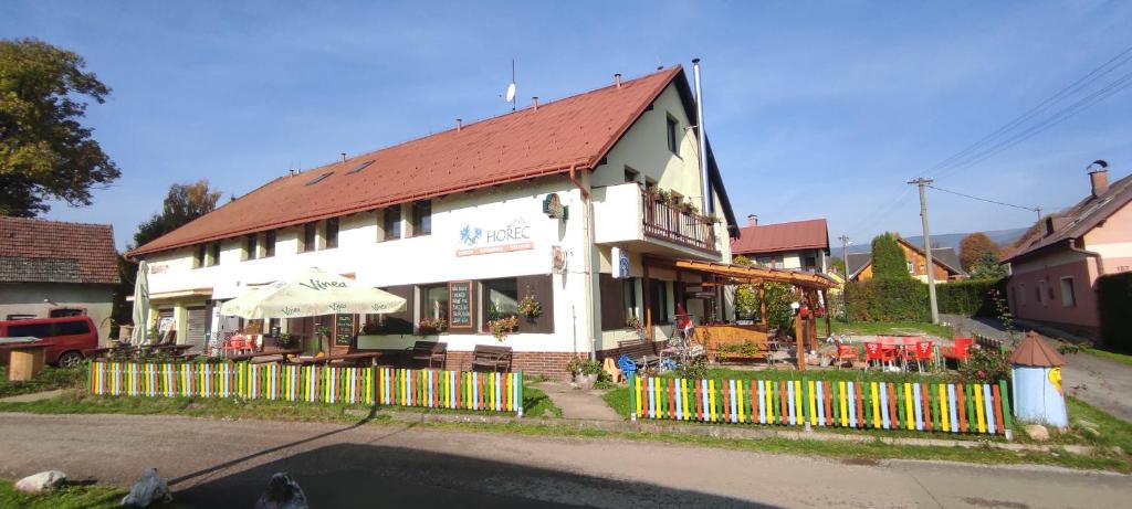 a white house with a fence in front of it at Pension Bílý Hořec in Vrchlabí