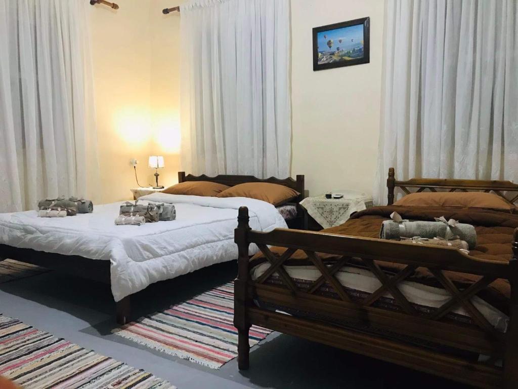 twee bedden in een kamer met gordijnen bij GuestHouse Vrontos, close to Monemvasia 