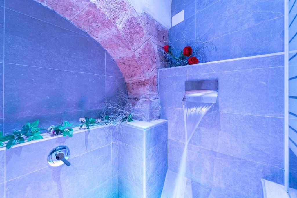 y baño con ducha de azulejos azules y morados. en B&B Eraclio, en Barletta