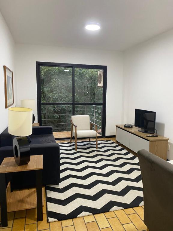 sala de estar con alfombra blanca y negra en Apart Alameda Santos - Paulista, en São Paulo
