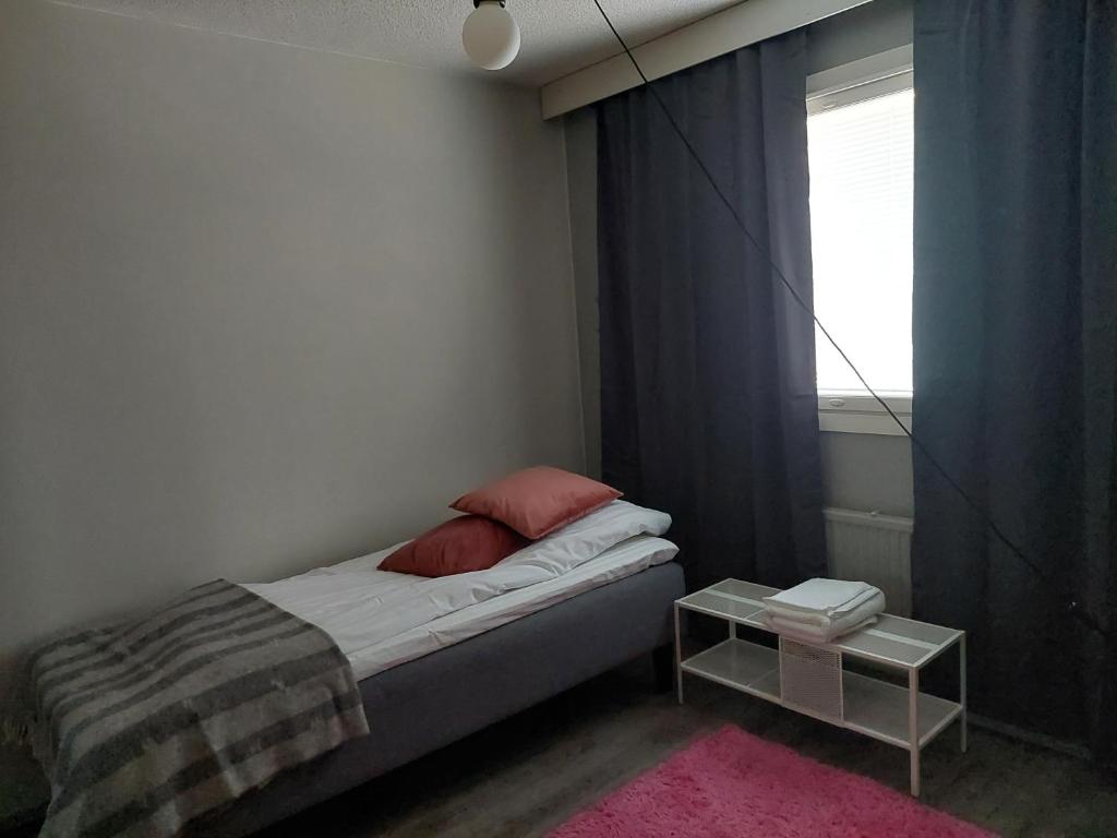 a small bedroom with a bed and a window at Ristimäenkatu in Mikkeli