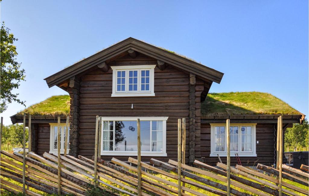 una casa di tronchi con tetto in erba di Awesome Home In Rn With Jacuzzi a Ron